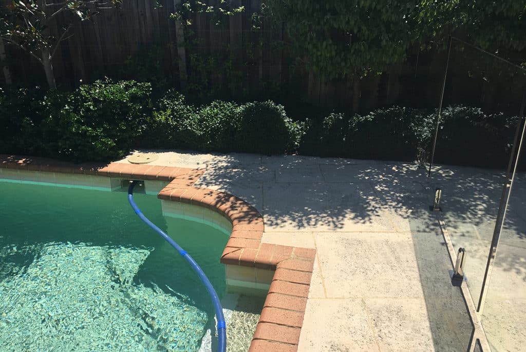 A before photo of the pool and surrounding paving
